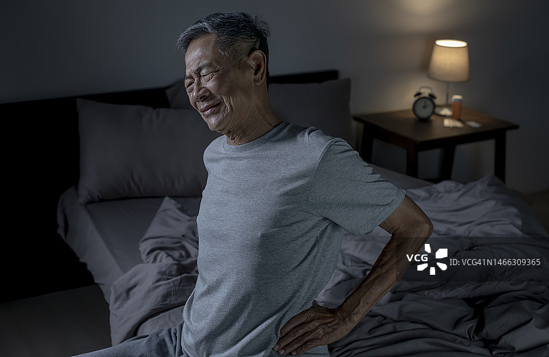 年长的亚洲男人在床上腰痛，保健问题概念图片素材