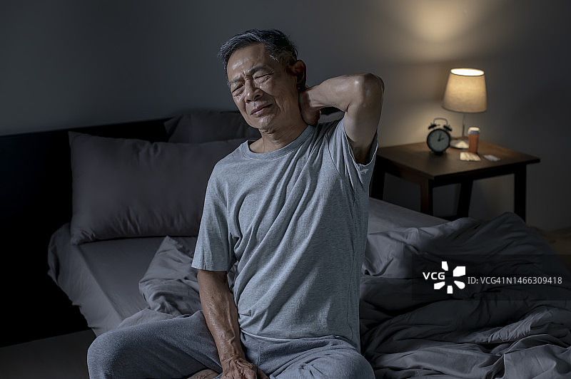 失眠： страдающий от боли в шее и плечах пожилой亚洲男子图片素材