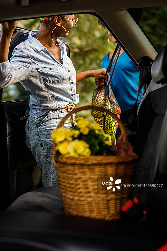 朋友们购物归来，在汽车后座上装载食品图片素材