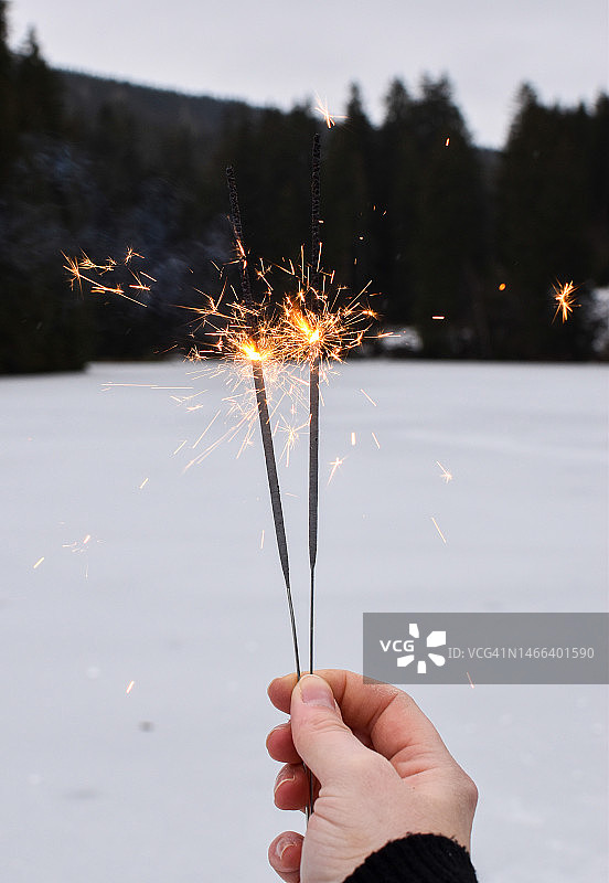 裁剪的手在德国韦尼格罗德的冬天拿着烟花棒图片素材