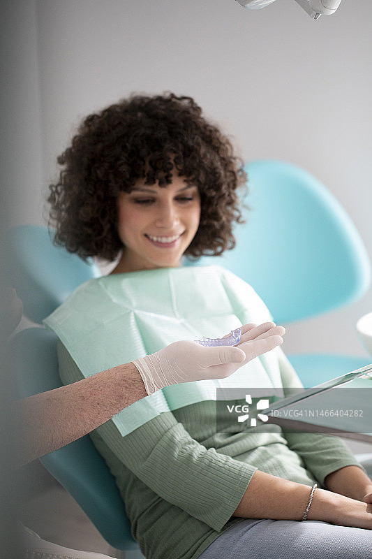 牙科诊所内戴牙齿保持器的女人图片素材