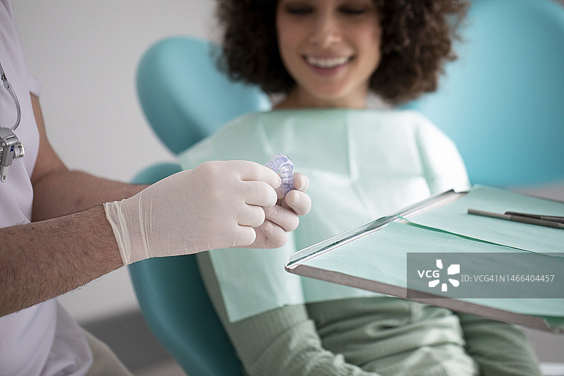 牙科诊所内戴牙齿保持器的女人图片素材