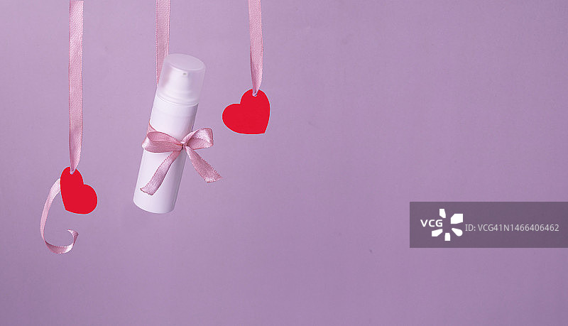 粉色背景上飞舞的红色纸质心形，情人节的象征图片素材