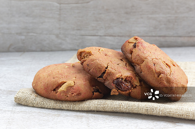 泰国白木桌上的草莓饼干腰果葡萄干图片素材