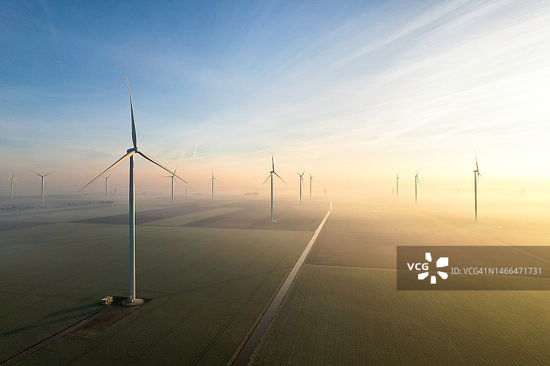 沐浴在壮丽晨光中的风力涡轮机图片素材
