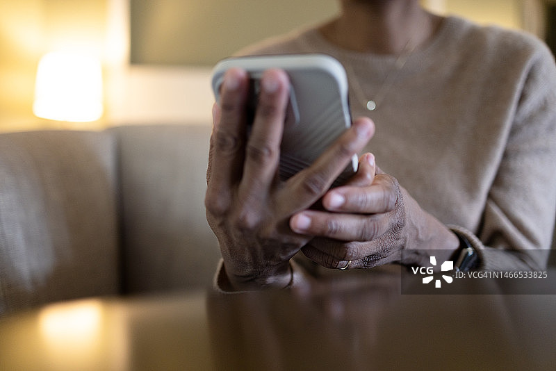 坐在桌旁使用智能手机的黑人女性图片素材