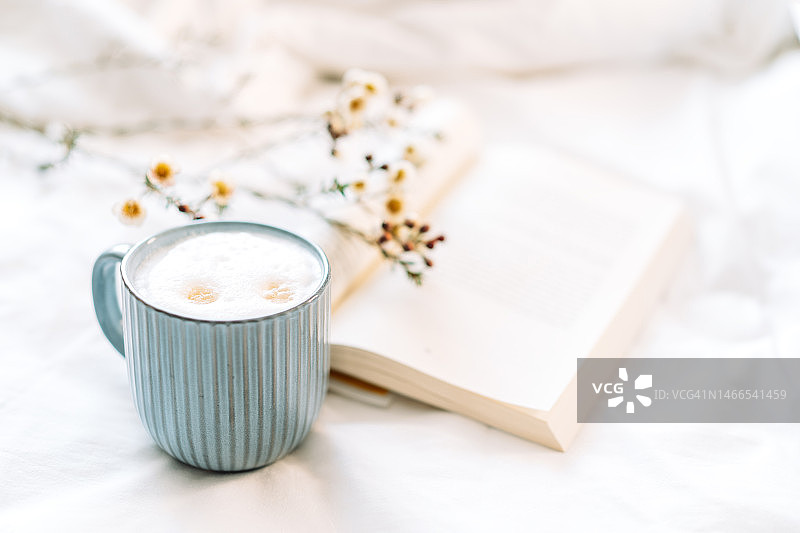 打开的书本上的蜡花，旁边是一杯咖啡图片素材