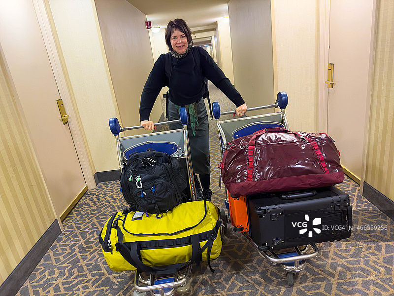 手推车上堆放着行李的女人图片素材