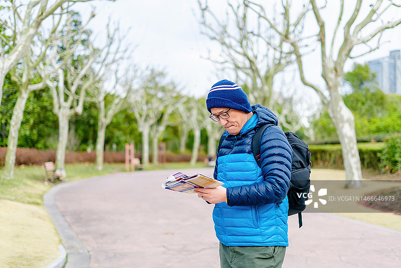 焦虑的男人拿着手机在街上寻找方向图片素材