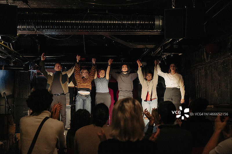 业余剧院表演结束后在舞台上牵手的男女演员图片素材