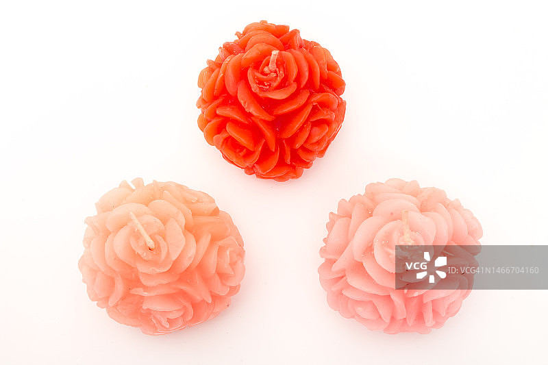 白色背景上玫瑰花造型的三个红色蜡烛图片素材