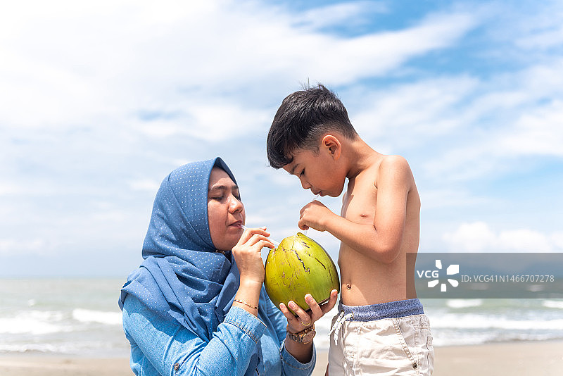 母亲和儿子分享椰子水图片素材