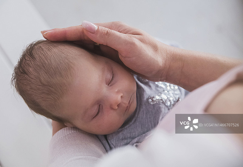 母亲抱着婴儿，抚摸着他的头图片素材