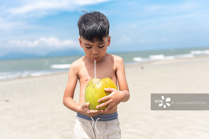 喝椰子水的小男孩图片素材