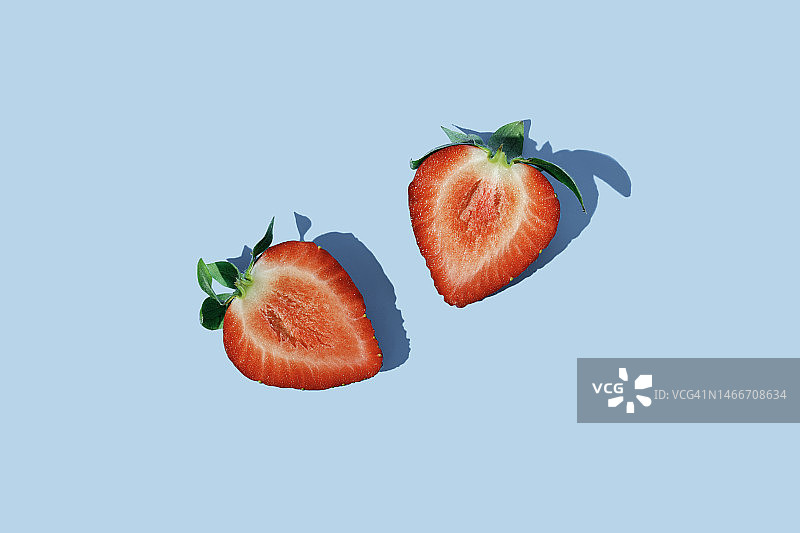 蓝色背景上的两片草莓图片素材