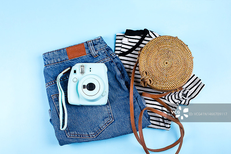 蓝色背景上的蓝色牛仔短裤、条纹衬衫和藤编包俯视图，哈萨克斯坦图片素材