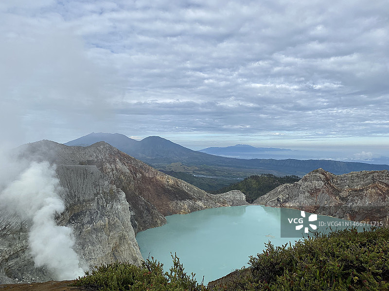 印尼东爪哇伊真火山的蓝色火山口与烟雾弥漫的硫磺全景图片素材
