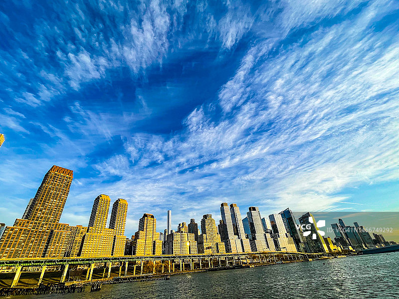 从纽约哈德逊河看到的现代公寓楼上方的壮丽天空图片素材