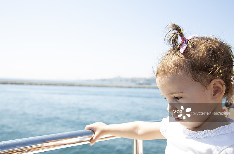 小女孩看着蓝色的大海图片素材