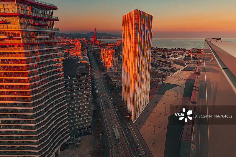 巴塞罗那城市天际线：现代摩天大楼间的壮丽日落图片素材