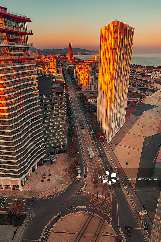 巴塞罗那城市天际线：现代摩天大楼间的壮丽日落图片素材