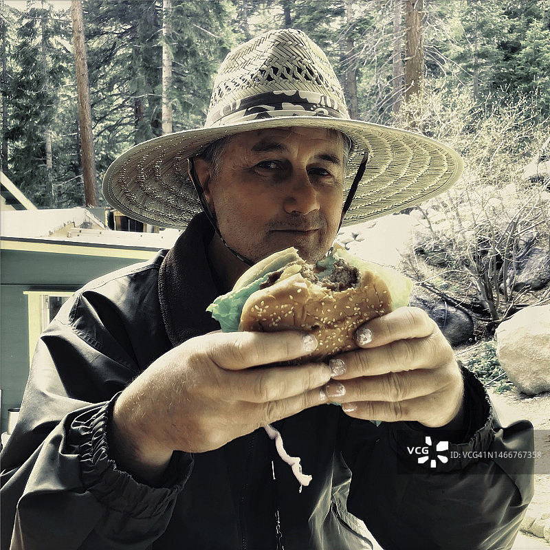 在户外吃汉堡的年长男人图片素材