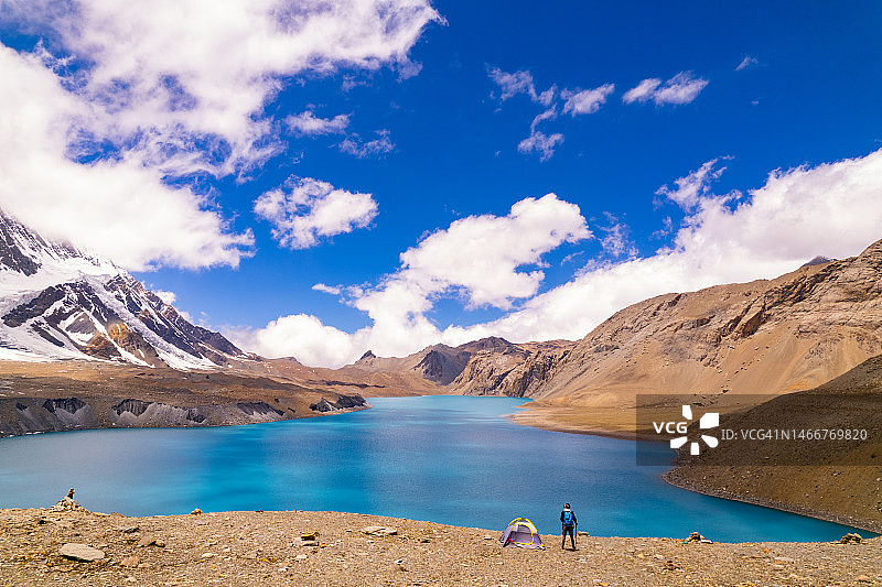 男人在喜马拉雅山脉湖岸露营图片素材