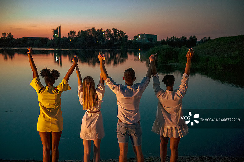 朋友们在湖边牵手休闲图片素材