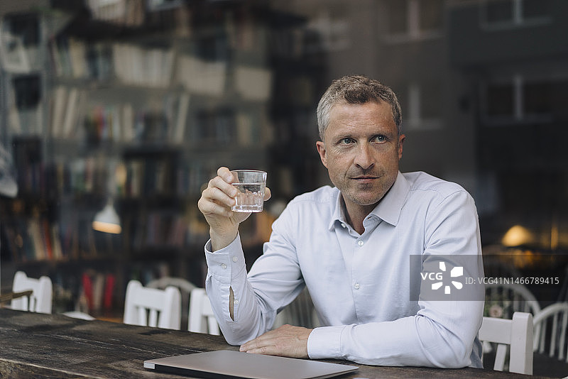 坐在咖啡馆里喝水的商人图片素材
