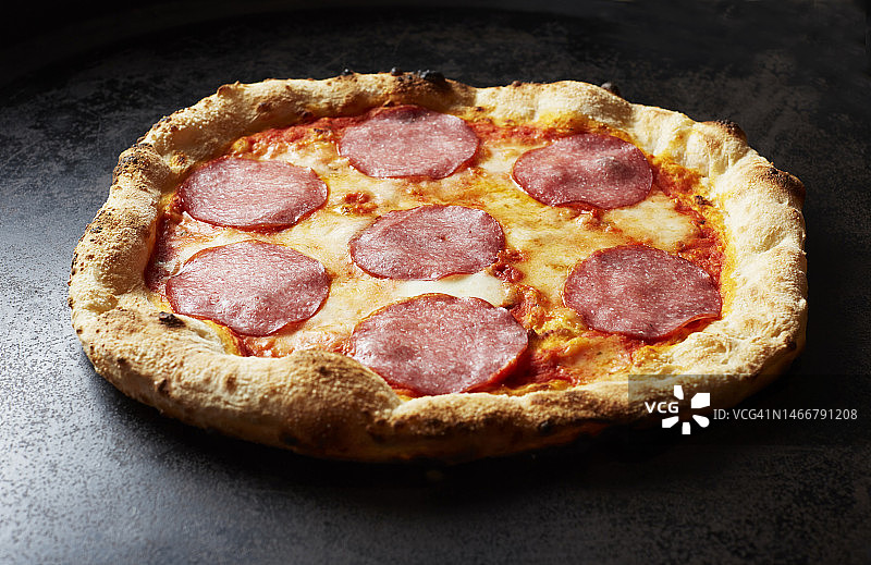 准备食用的萨拉米香肠披萨的影棚照片图片素材