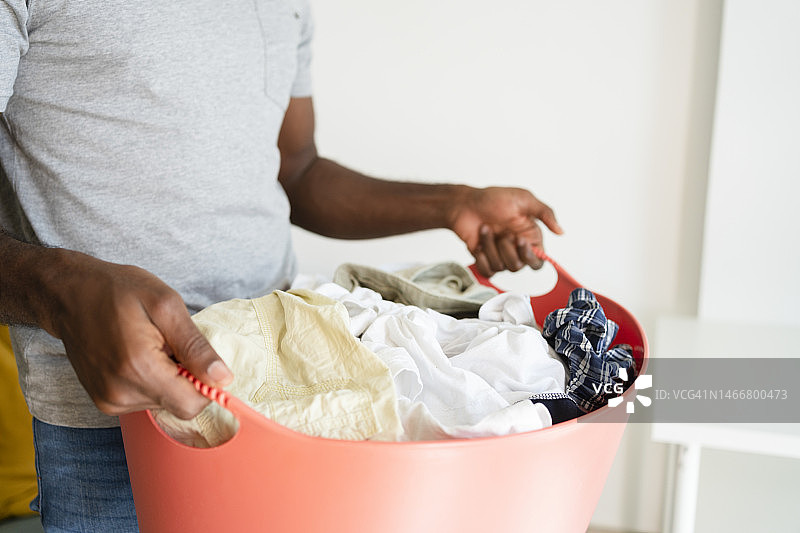 男子在家手持洗衣篮图片素材