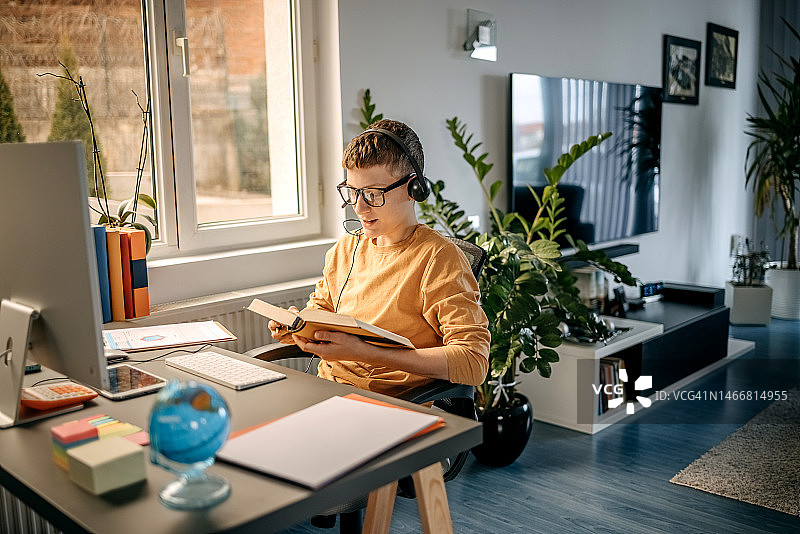 男孩在家使用台式电脑上网课图片素材