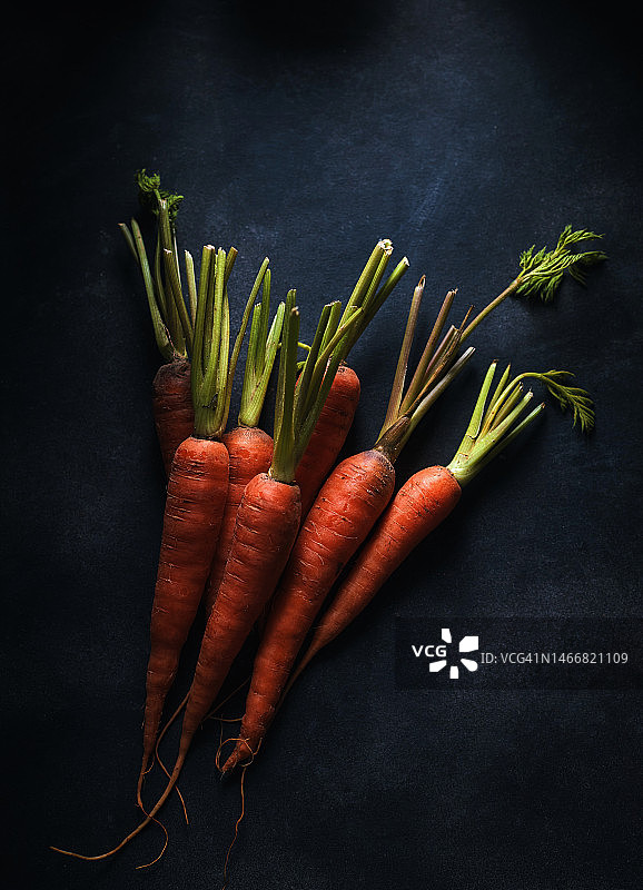 深色地板上的有机胡萝卜图片素材