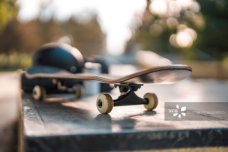 滑板公园长椅上的滑板、咖啡杯、背包和头盔图片素材