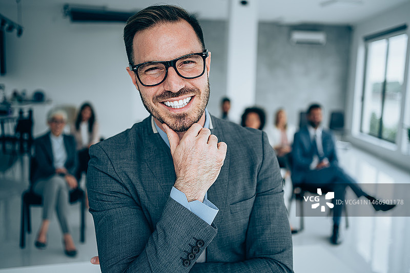 在大会堂里对着同事们自信的演讲者图片素材