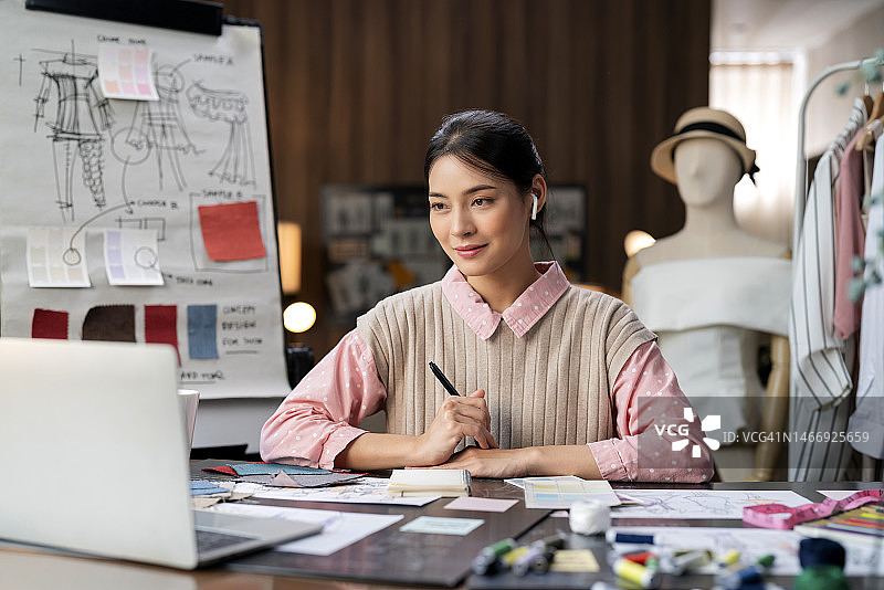 亚洲女服装设计师在线视频会议，选择新款面料图片素材