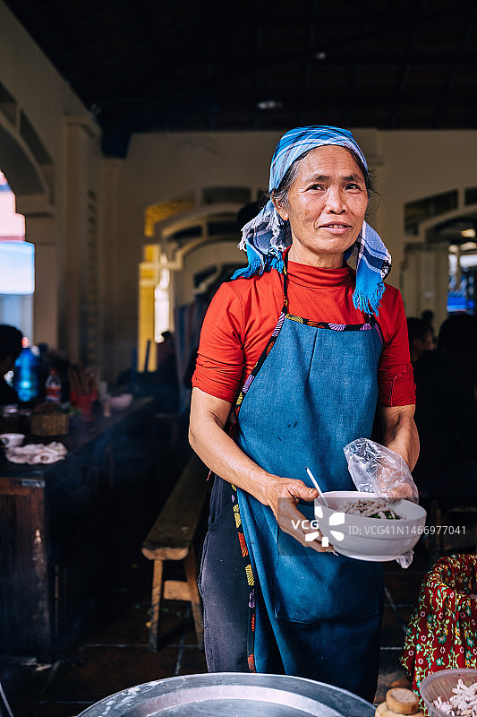 在越南北河市场做米粉汤的中国少数民族老年妇女肖像图片素材