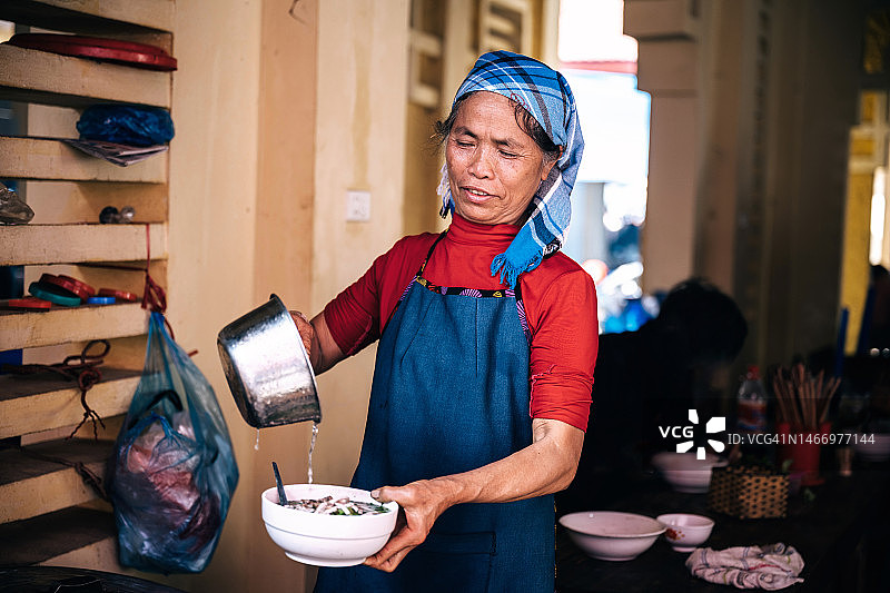 越南巴哈市场：当地老年妇女在煮面条图片素材