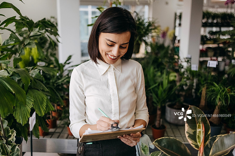 在园艺中心做笔记的工人图片素材