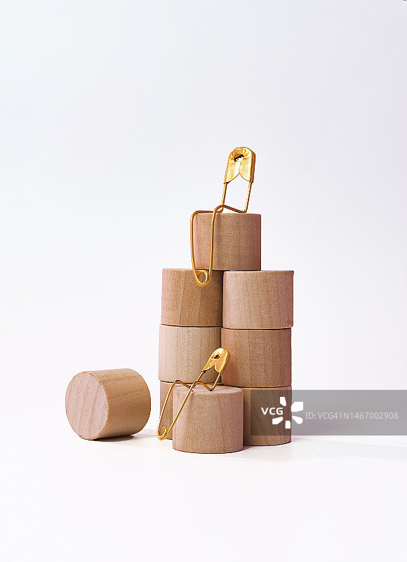 金色金属安全别针，置于不同高度的木块上图片素材