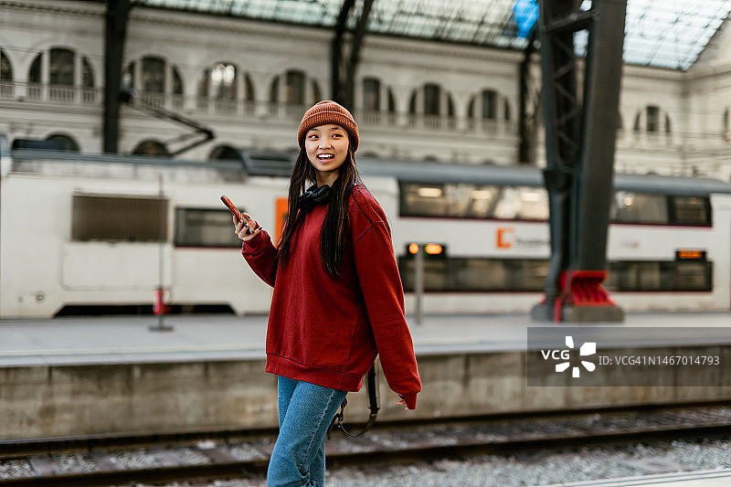 在火车站使用智能手机的年轻时尚亚洲女性图片素材