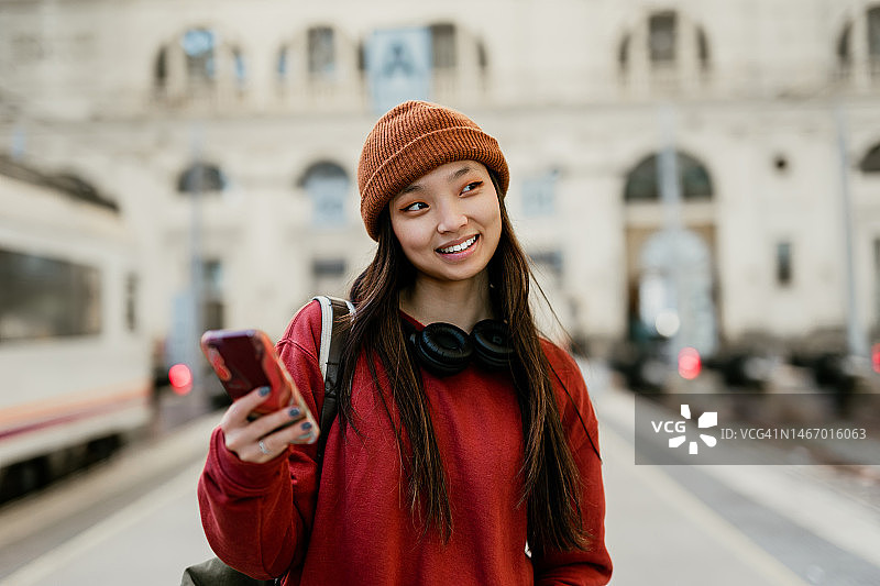 在火车站使用智能手机的年轻时尚亚洲女性图片素材