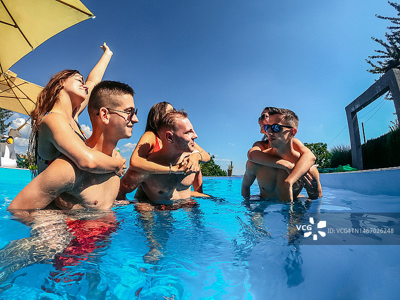 在游泳池里玩耍的年轻情侣图片素材