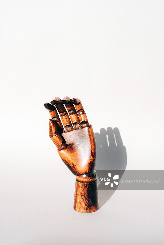 灰色背景上的棕色木制手，人体模型：医学、健康与护理图片素材