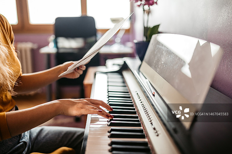 在家弹钢琴的年轻女人图片素材