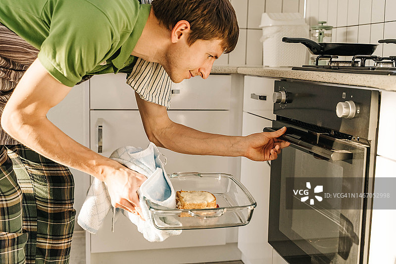 年轻男人在明亮厨房做饭图片素材