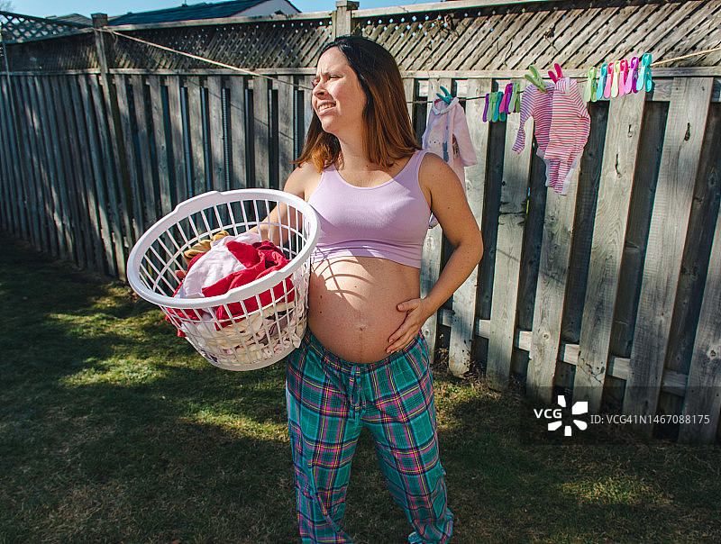 孕妇在后院晾晒婴儿衣服图片素材
