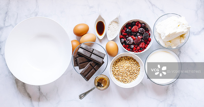 巴斯克芝士蛋糕的食材：鸡蛋、香草精、奶酪、杏仁、红色水果和巧克力图片素材
