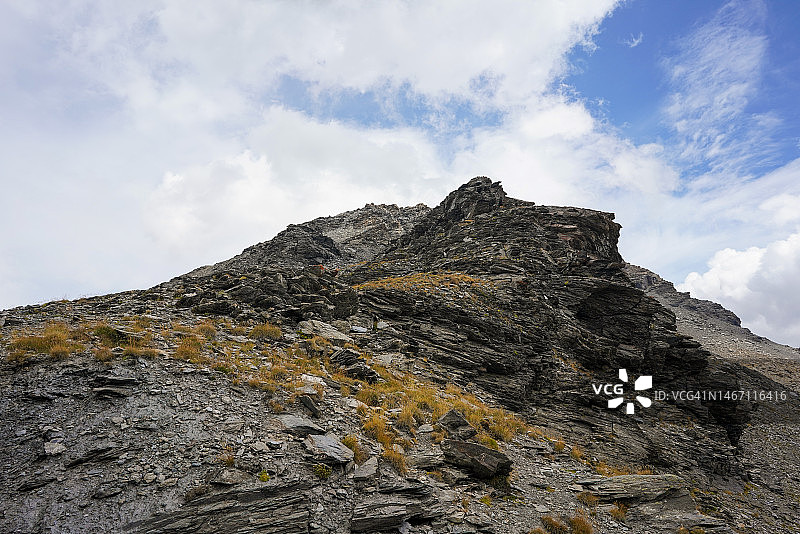 蒙塞尼斯山：夏季多云天空下的法意山脉图片素材