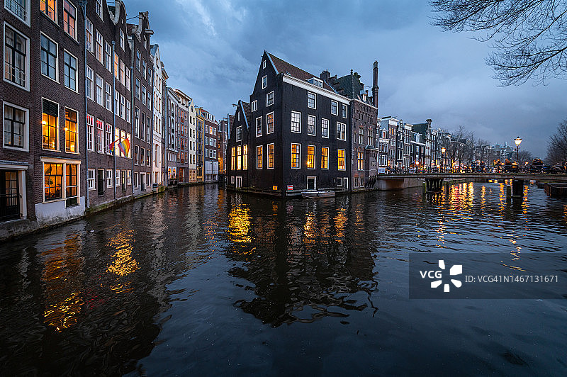 黄昏时分，阿姆斯特丹运河房屋倒影在平静的运河上图片素材